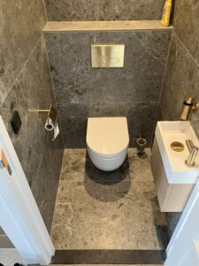 Toilet met luxe natuursteenafwerking en goudkleurige accenten