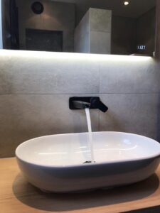 Badkamer met stenen wastafelmeubel, vierkante led verlichte spiegel